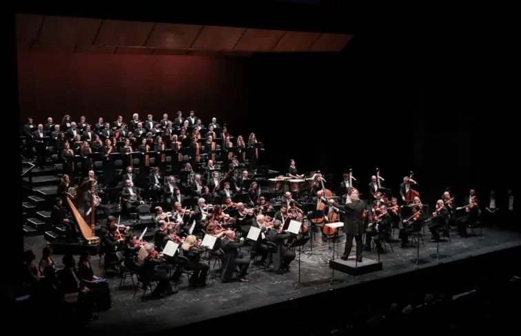 A orquestra sinfónica portuguesa e o coro do teatro nacional são carlos em palco.